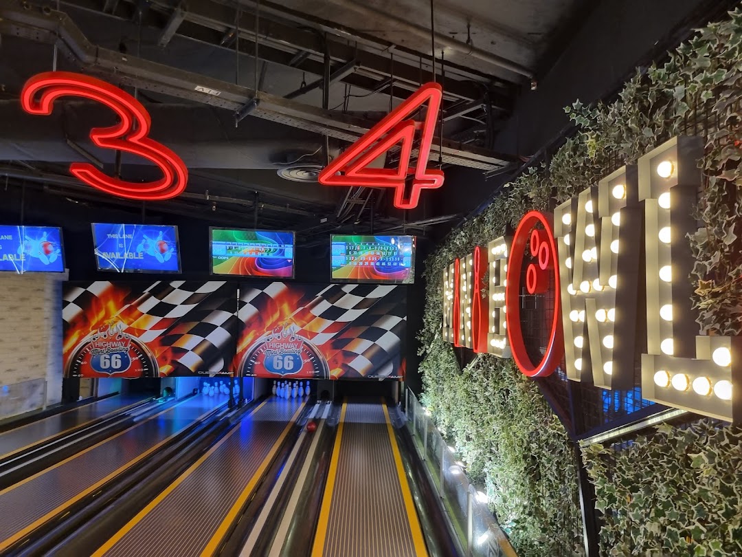 Vibrant bowling lanes with neon signs and score screens at Timezone Westgate.