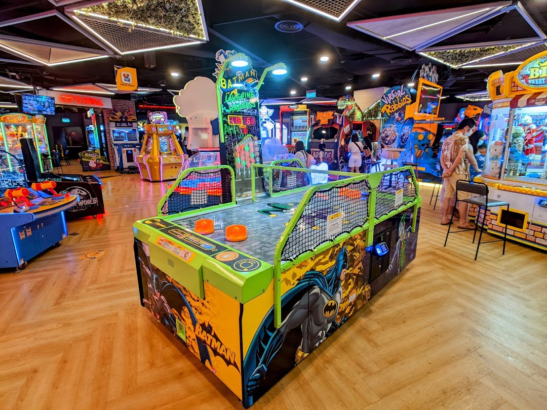 An vibrant arcade interior filled with various game machines and visitors enjoying themselves.