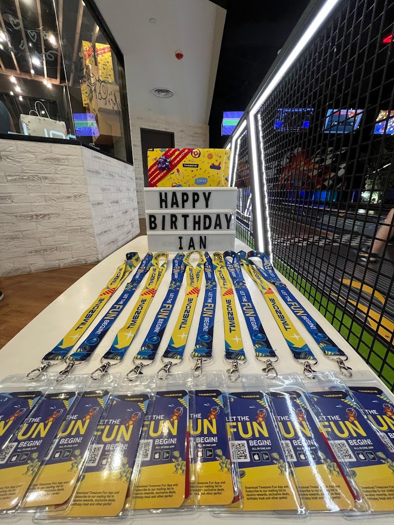 A table set up for a birthday party at Timezone, featuring lanyards and promotional materials.