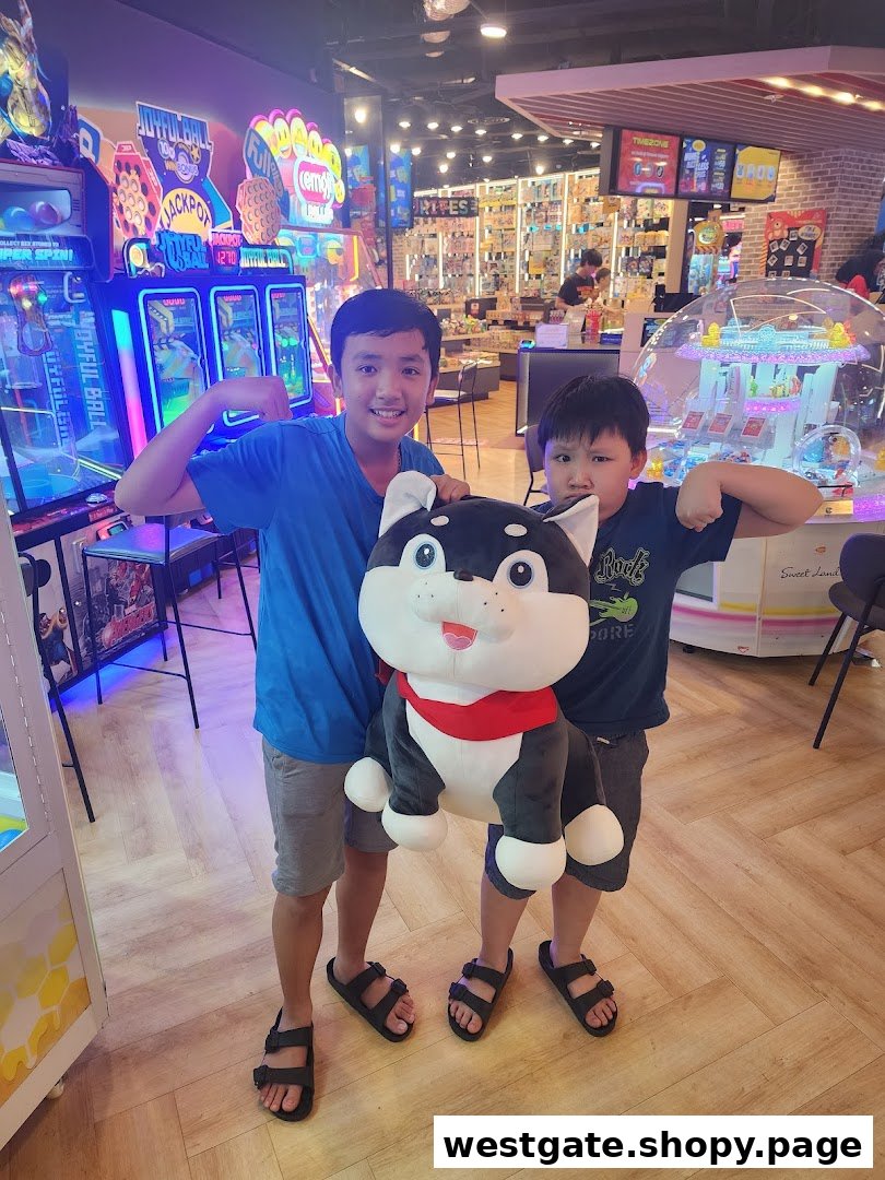 Two boys pose with a large plush toy inside a vibrant arcade with various game machines.