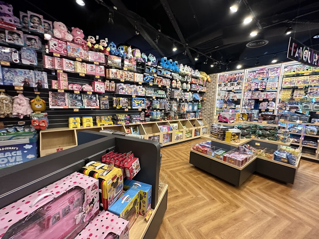 A brightly lit prize shop interior with shelves full of toys, plushies, and merchandise.