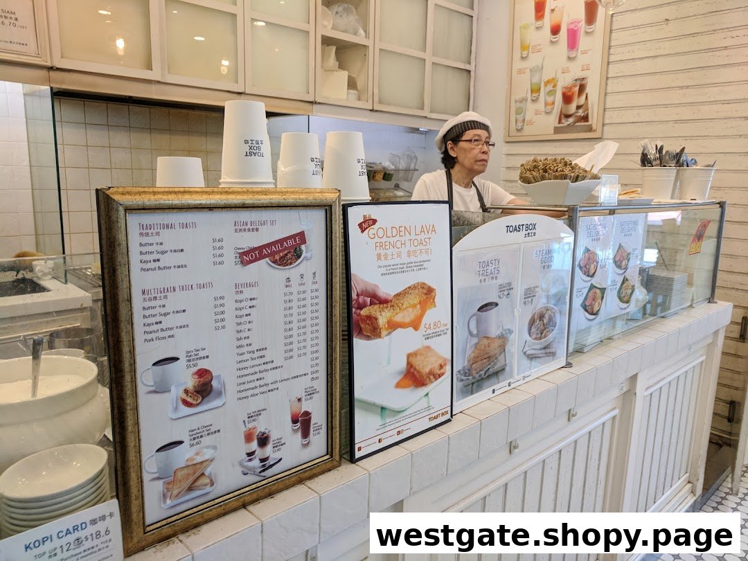 A staff member behind the counter at Toast Box, featuring prominent menu displays and food items.