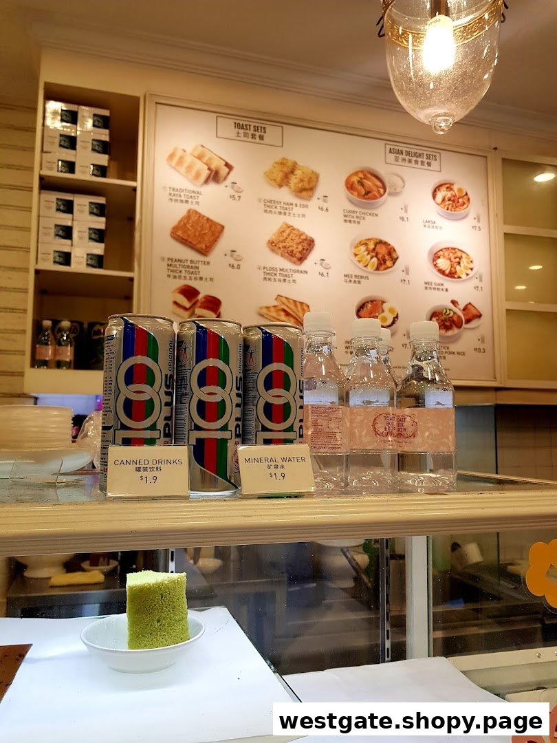 An interior shot of Toast Box, featuring a menu board with toast and Asian delight sets, alongside canned drinks and mineral water.