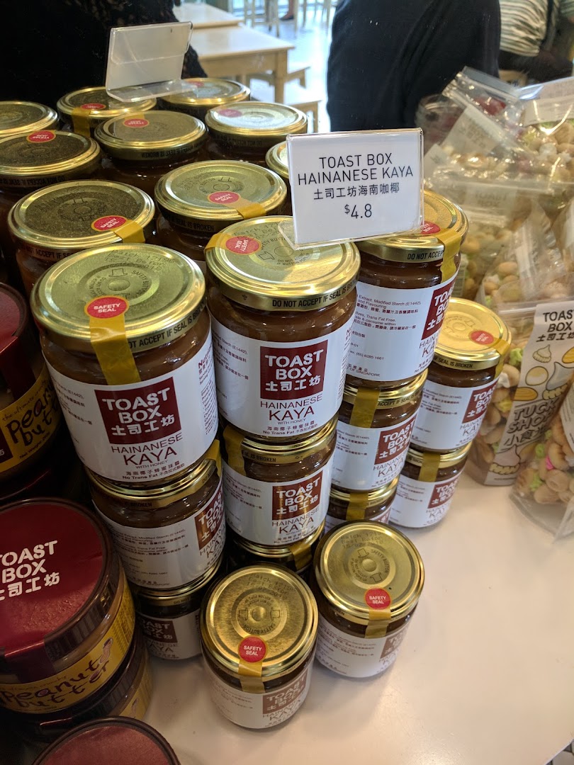 A retail display of Toast Box Hainanese Kaya and peanut butter jars for sale.