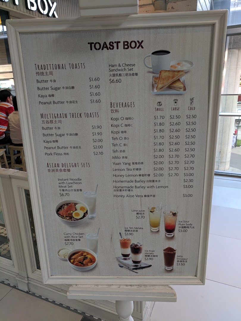 A detailed menu board for Toast Box, showcasing traditional toasts, Asian delight sets, and various beverages.