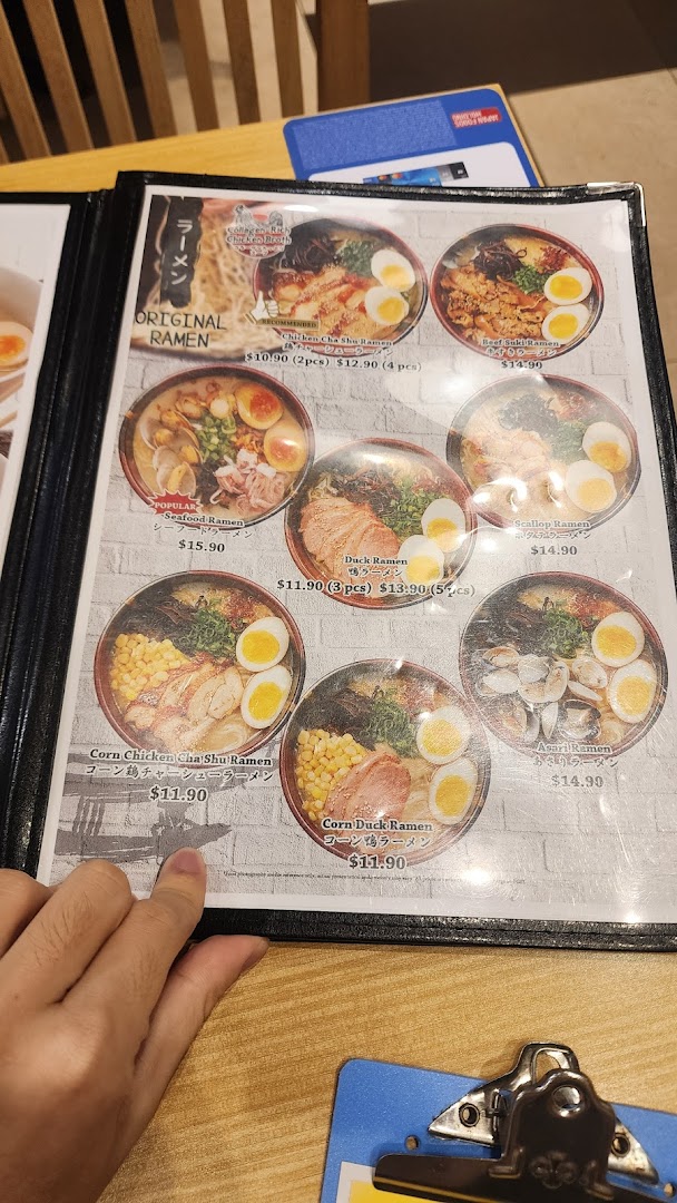 A close-up view of a ramen menu displaying various noodle dishes with prices and images.