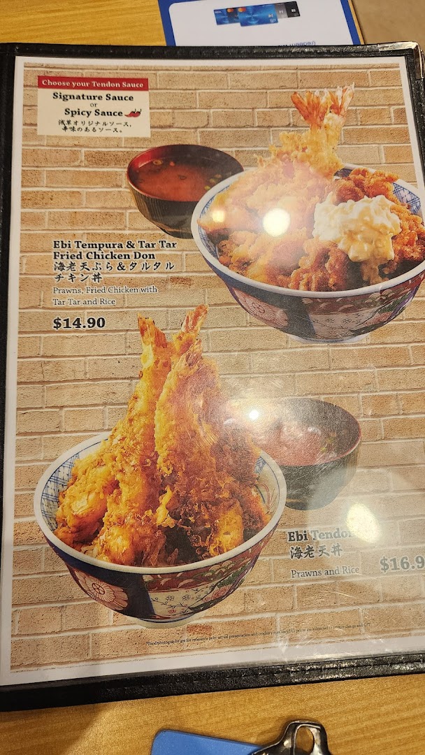 A close-up of a Japanese restaurant menu featuring Ebi Tempura and Tendon dishes with prices.