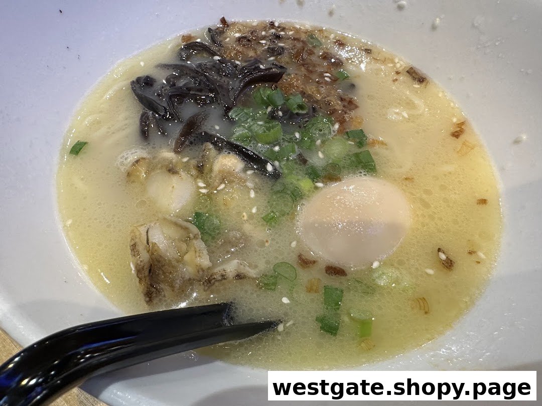 A close-up of a creamy ramen bowl with wood ear mushrooms, green onions, sesame seeds, and a soft-boiled egg.