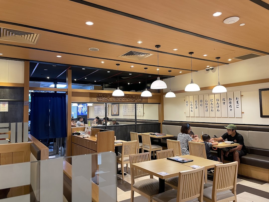 An inviting interior view of Tokyo Shokudo Westgate, featuring wooden decor and comfortable seating with diners.