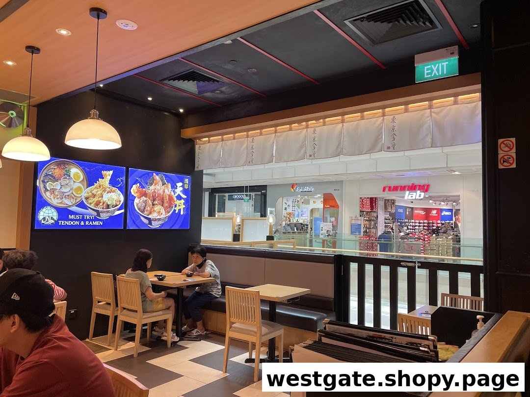 Interior view of Tokyo Shokudo Westgate, showing diners and digital displays featuring Tendon and Ramen.