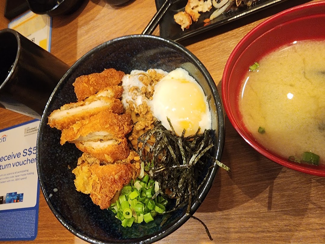 A delicious katsu don with a poached egg, seaweed, and spring onions, served with miso soup.