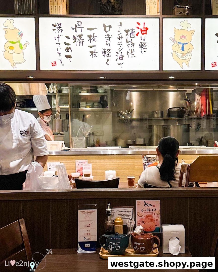 An interior view of Tonkatsu by Ma Maison, featuring the open kitchen and a dining table.