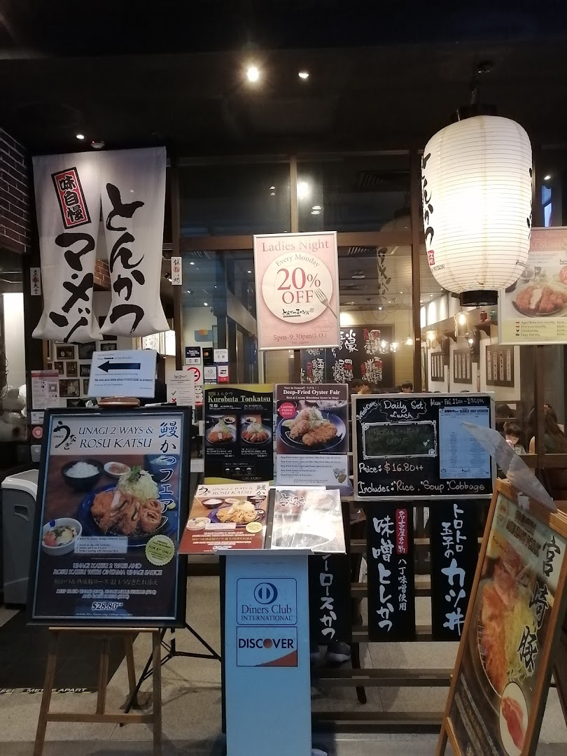 The shopfront of Tonkatsu by Ma Maison, featuring promotional signs and a traditional Japanese lantern.