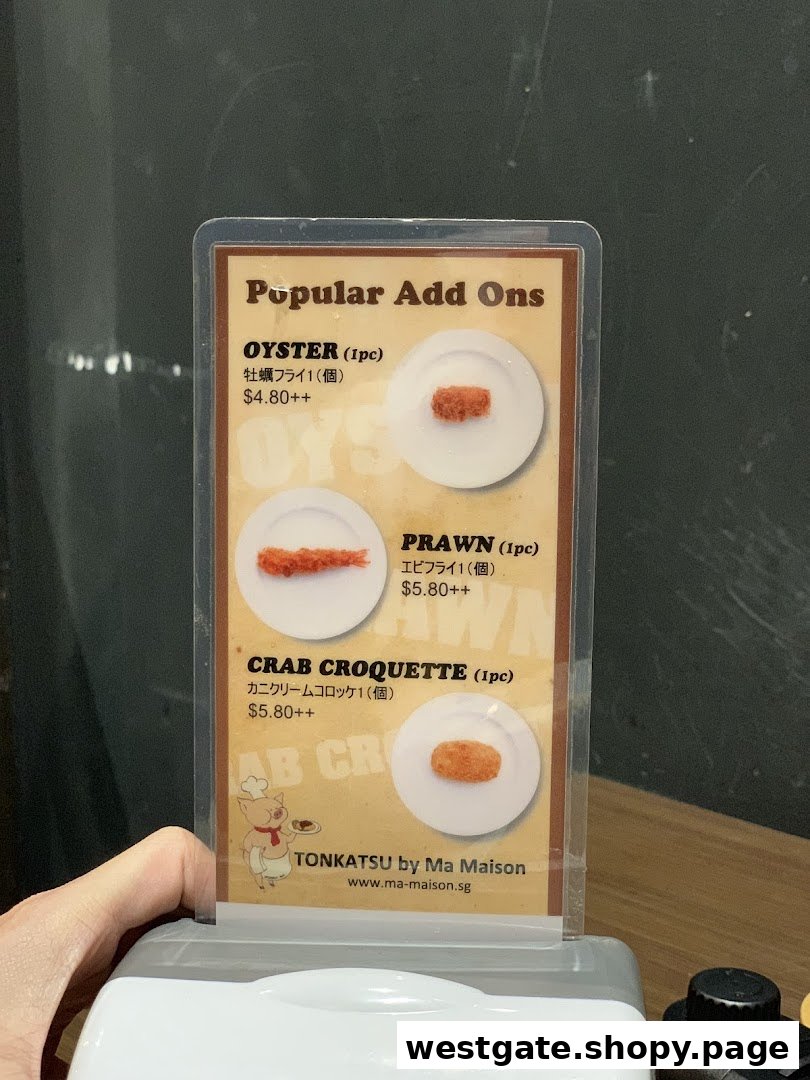 A table-top display showcasing popular add-on items and their prices from Tonkatsu by Ma Maison.
