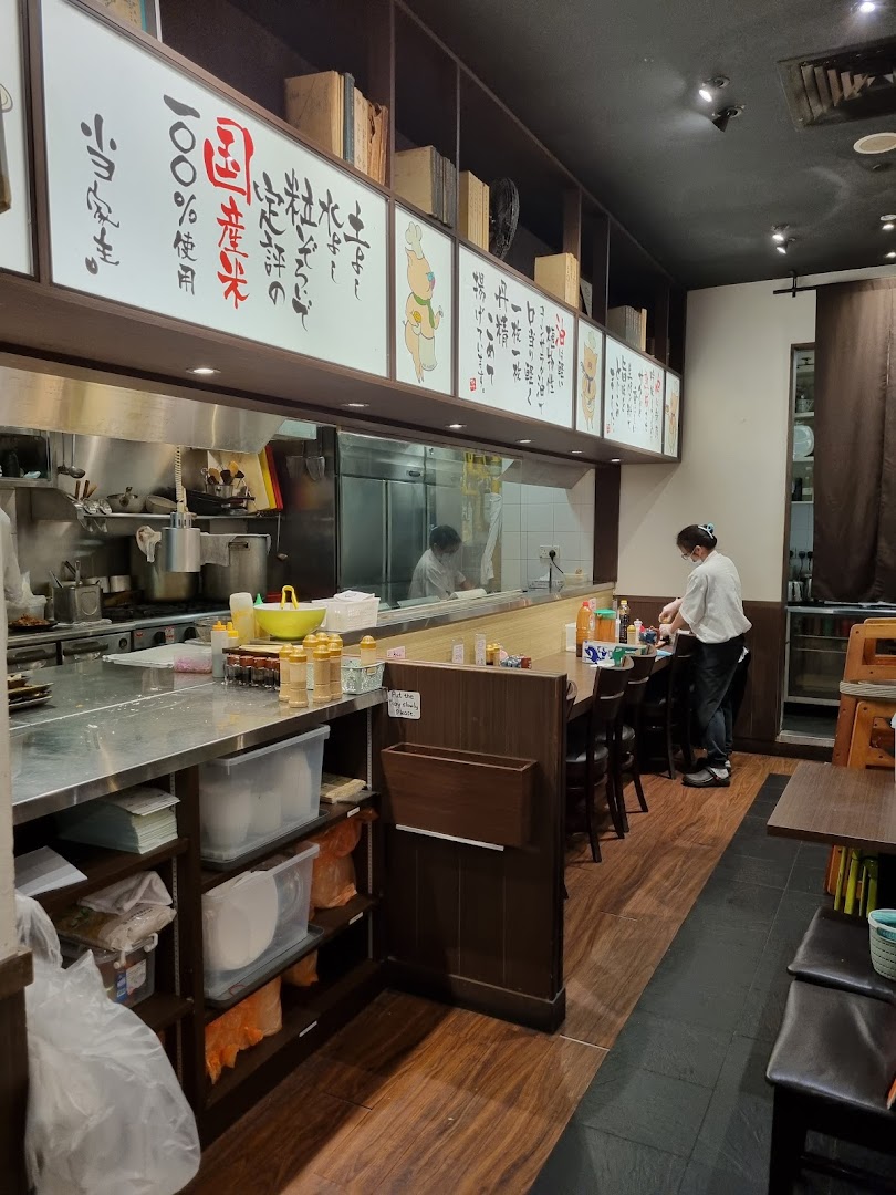 An interior view of Tonkatsu by Ma Maison, showing the open kitchen counter and dining area.