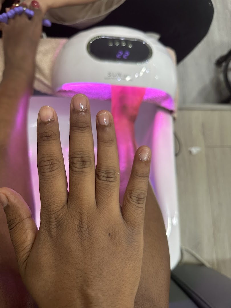 A close-up of a hand under a UV nail lamp during a manicure service at Top Feeling.