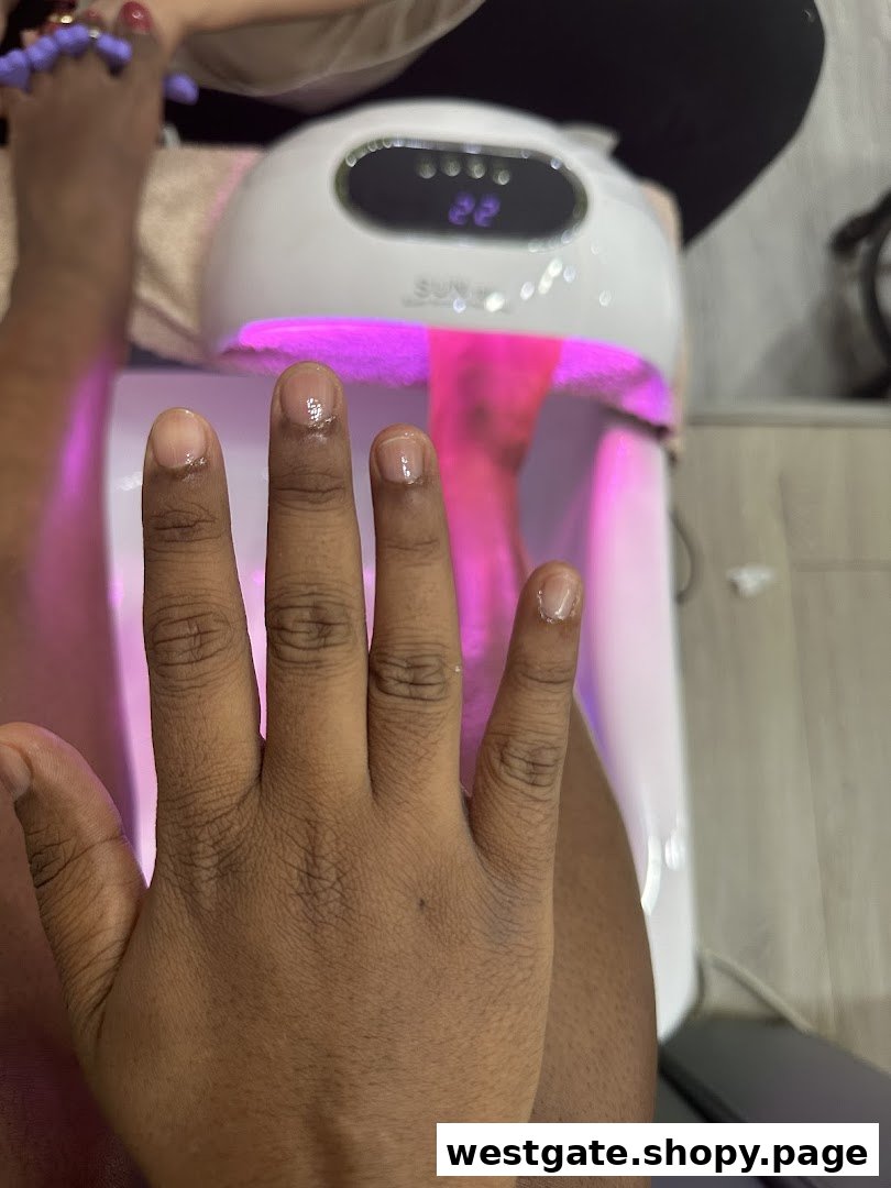 A close-up of a hand under a UV nail lamp during a manicure service at Top Feeling.