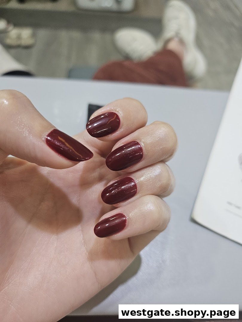 A close-up of a hand showcasing freshly painted dark red nails, likely after a salon service.