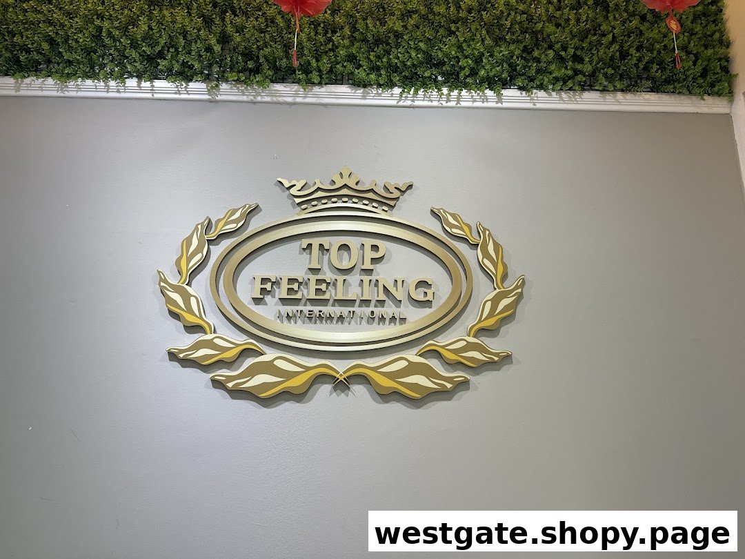 A close-up of the elegant gold 'Top Feeling International' logo on a grey wall with green foliage above.