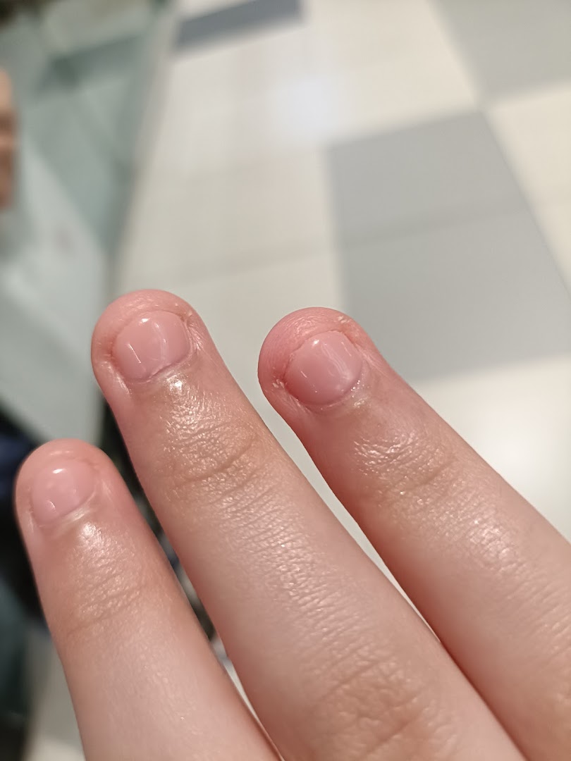 Close-up of fingers showcasing freshly manicured nails with a natural, glossy finish.