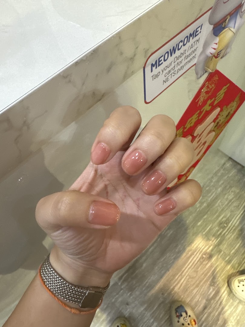 A close-up of a hand showcasing freshly manicured nails with a natural, glossy finish.