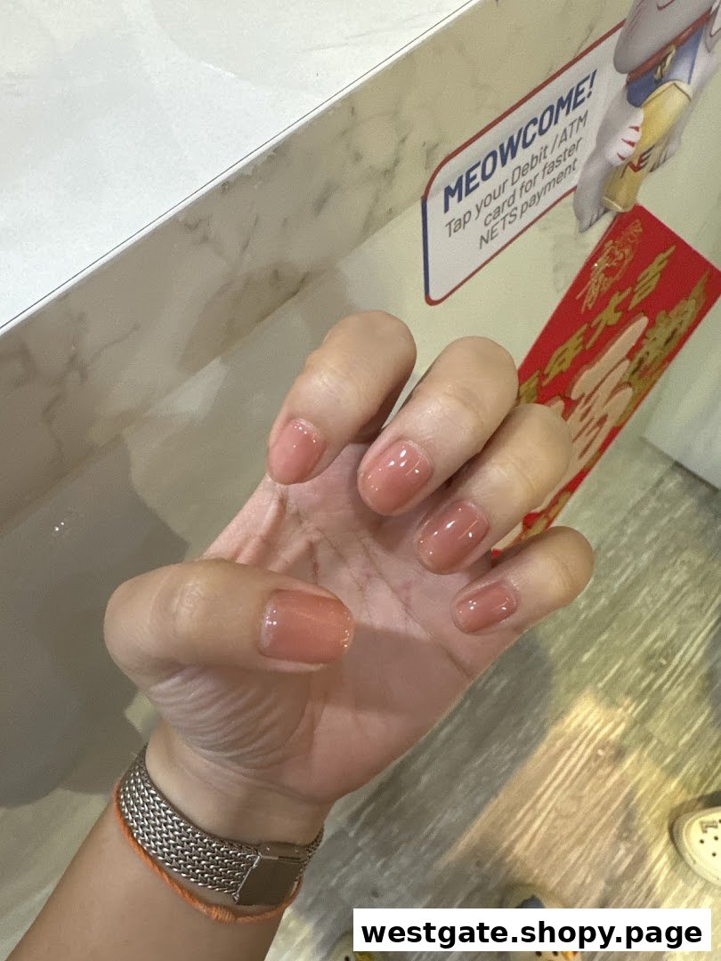 A close-up of a hand showcasing freshly manicured nails with a natural, glossy finish.