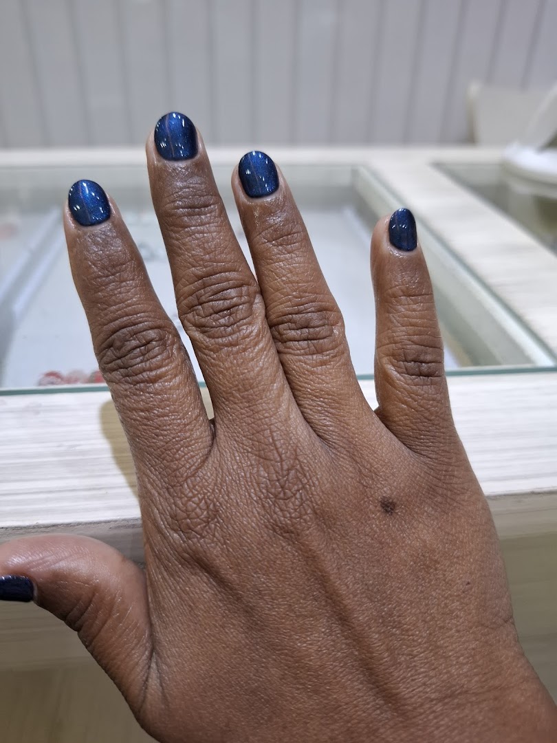 A close-up of a hand showcasing freshly manicured nails with a shimmering blue polish.