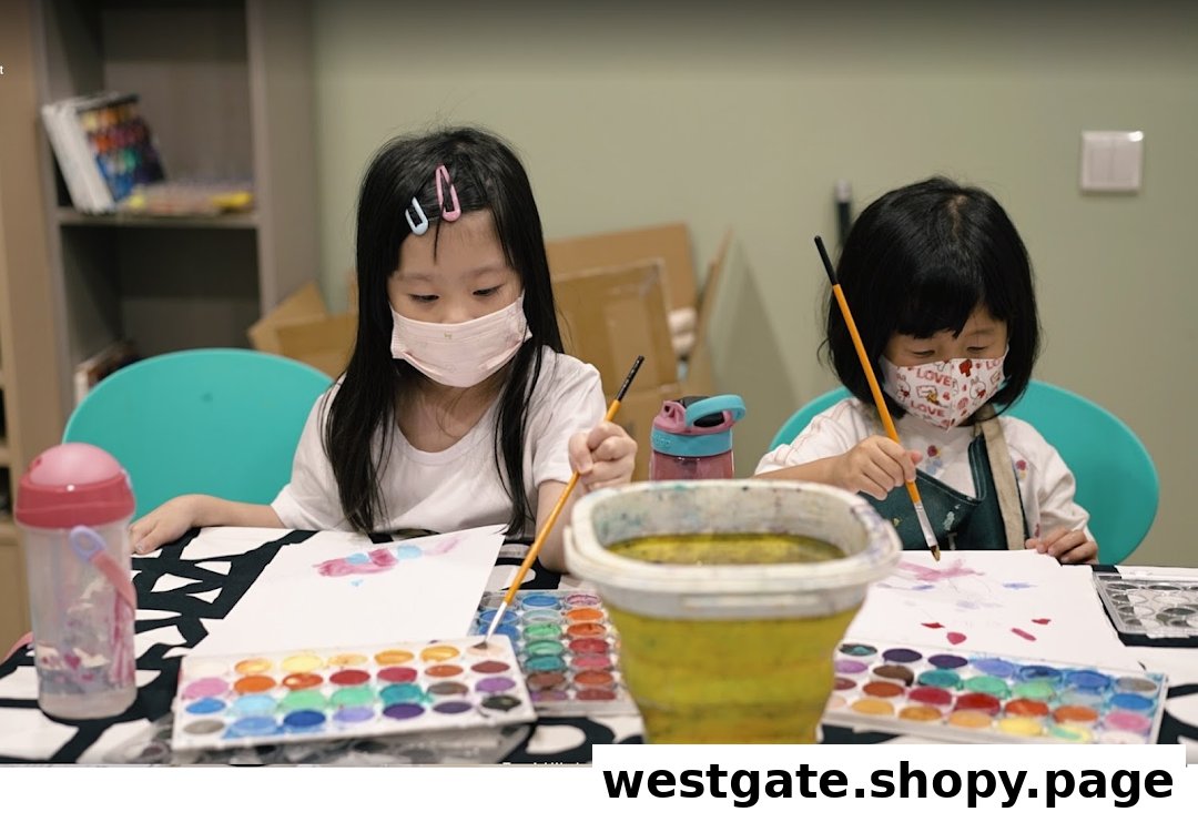 Two young girls wearing masks are engaged in watercolor painting at a table.