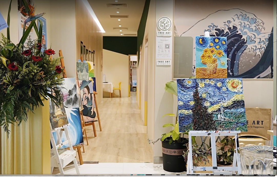 A vibrant art studio hallway featuring easels with paintings, lush plants, and a welcoming creative atmosphere.