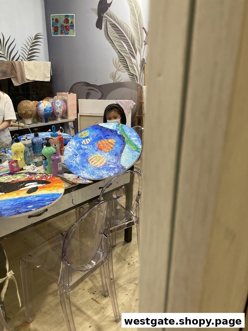 A child works on a vibrant painting in an art studio filled with creative projects and supplies.