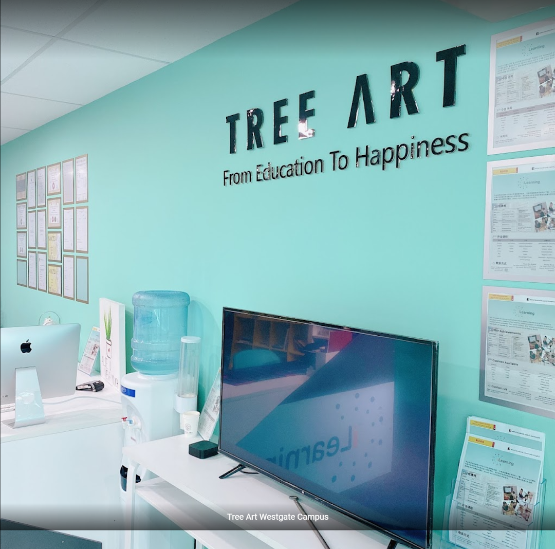 A bright, modern interior of Tree Art learning center with a prominent logo, computers, and display screens.