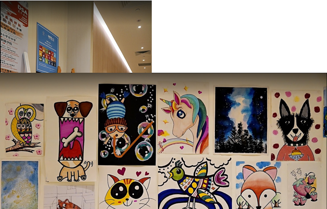 A wall displaying colorful children's artwork, including animals and abstract designs, at an art campus.