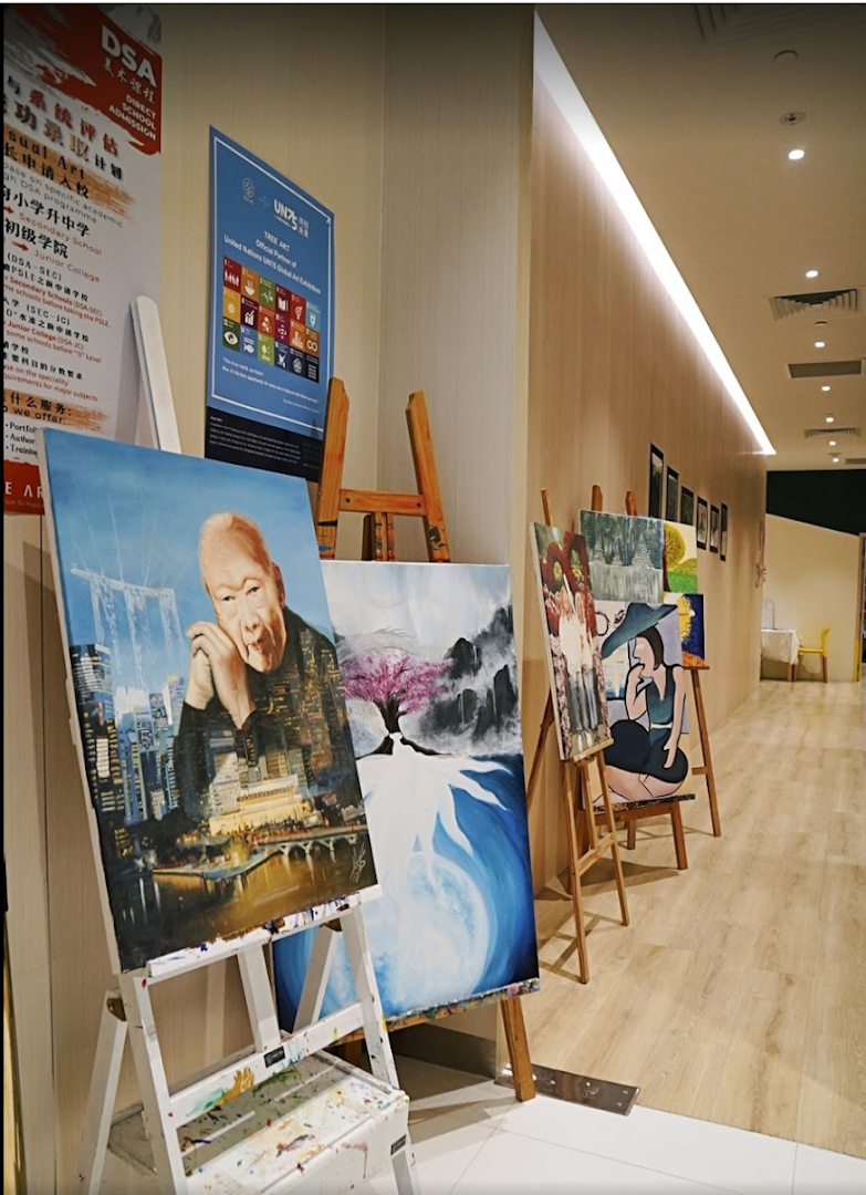 An interior view of an art school hallway displaying various student artworks on easels.