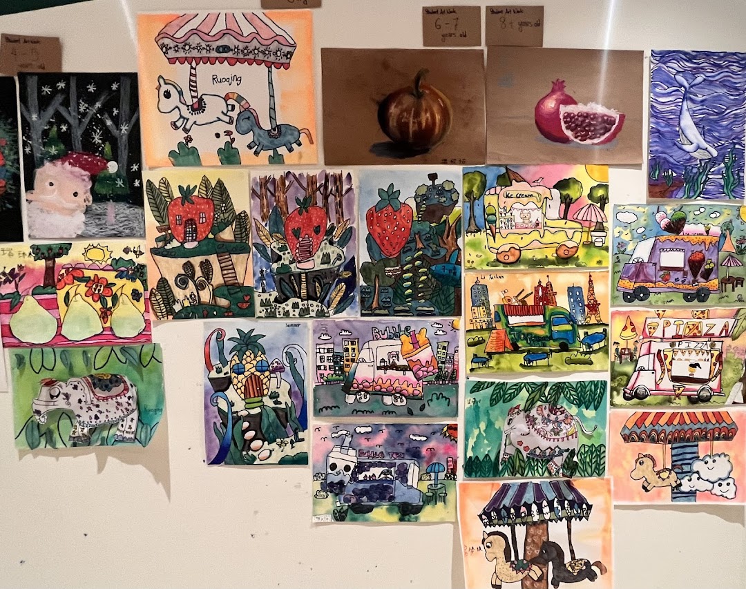 A vibrant display of children's artwork, showcasing various creative drawings and paintings on a white wall.