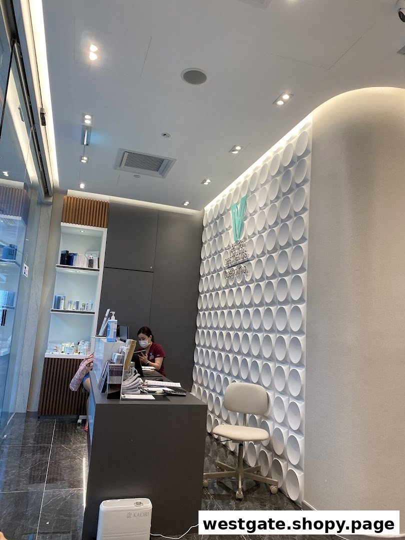 A modern reception area of V Medical Aesthetics & Laser Clinic with a staff member at the desk.