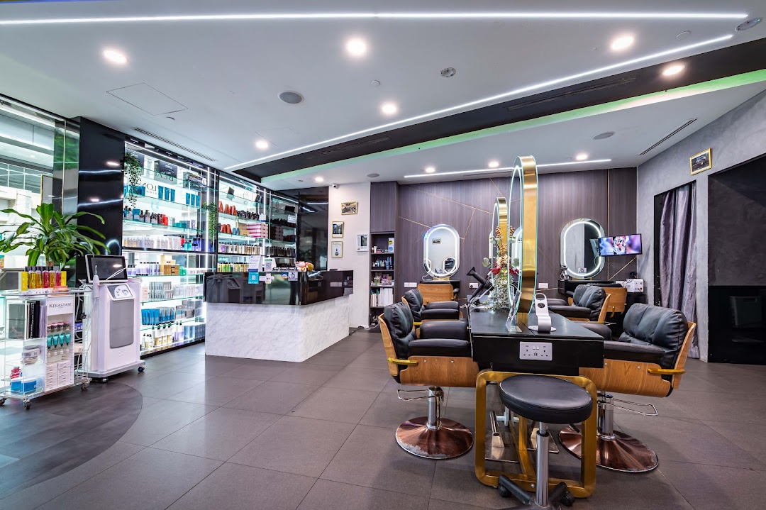 Interior view of a modern hair salon with styling stations, product displays, and a reception counter.