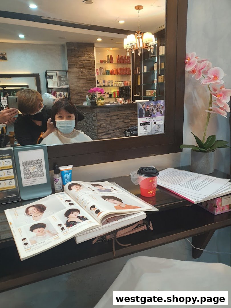 A customer receives a haircut at Vintage Studio VS Salon, with a style book and products visible.