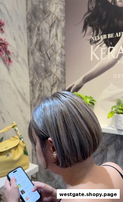 A customer with freshly styled hair, possibly highlights, looking at a phone inside a modern salon.