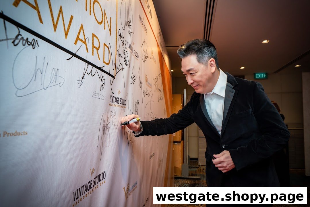 A man in a suit signs a banner featuring the 'Vintage Studio' logo and 'Hairdressing Spa'.