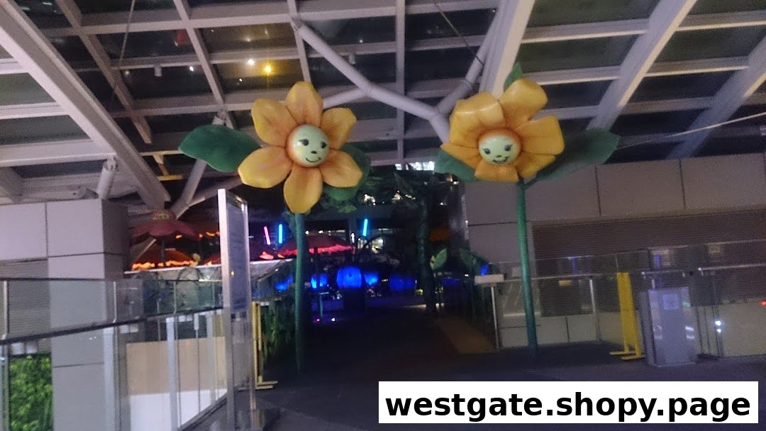 The entrance to Westgate Kids Club, featuring large, smiling flower decorations and colorful lights.