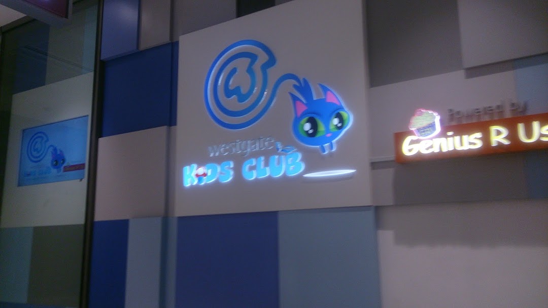 Illuminated sign for Westgate Kids Club featuring a playful blue cat logo and 'Powered by Genius R Us'.