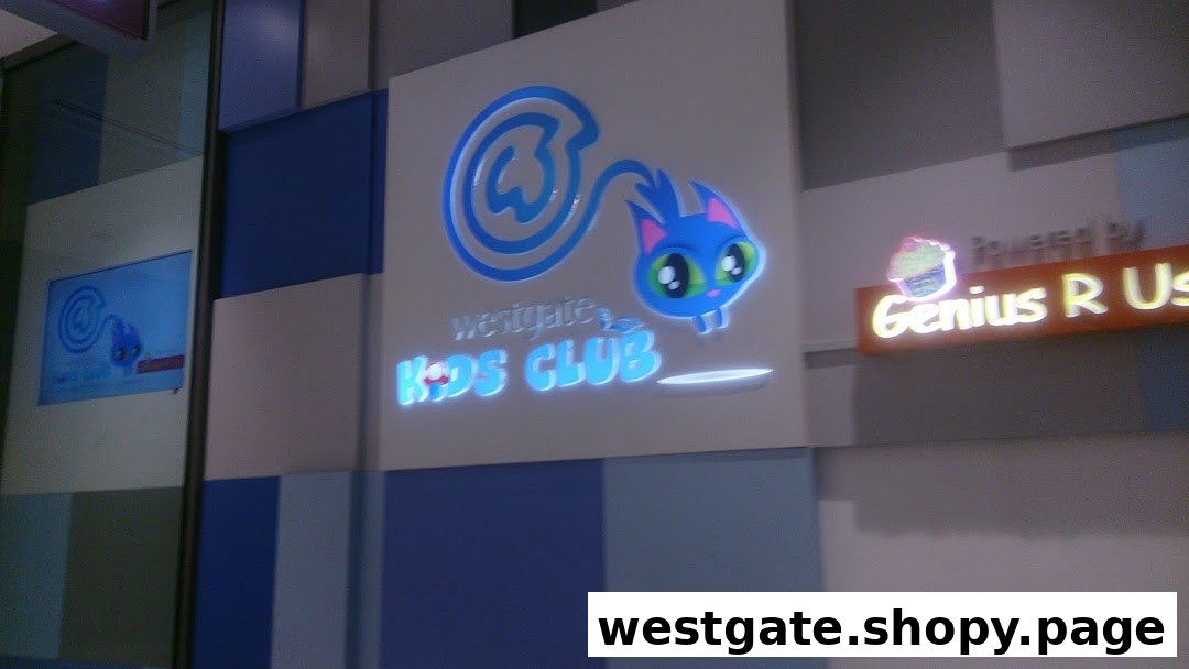 Illuminated sign for Westgate Kids Club featuring a playful blue cat logo and 'Powered by Genius R Us'.