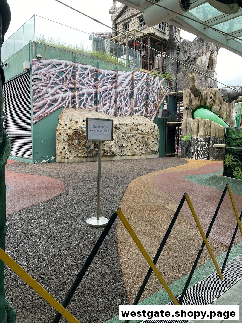 An outdoor adventure play area with climbing walls and treehouse structures, currently closed due to weather conditions.