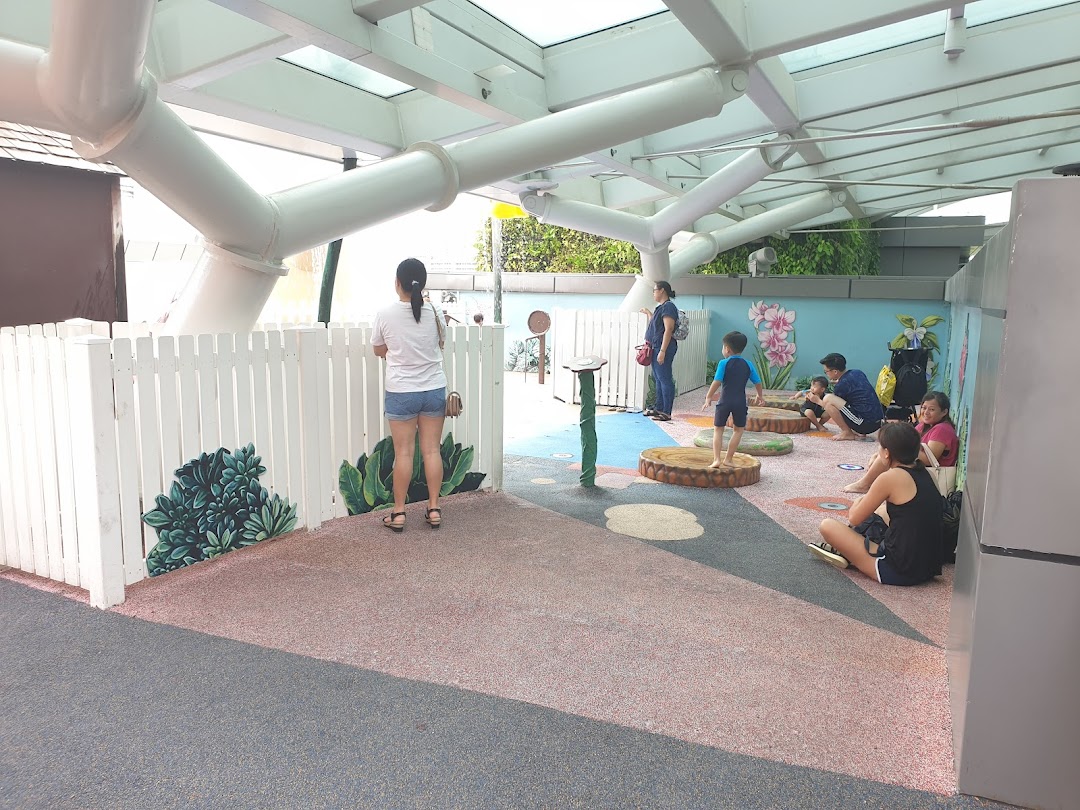 Families and children enjoy a vibrant indoor play area with soft flooring and interactive elements.