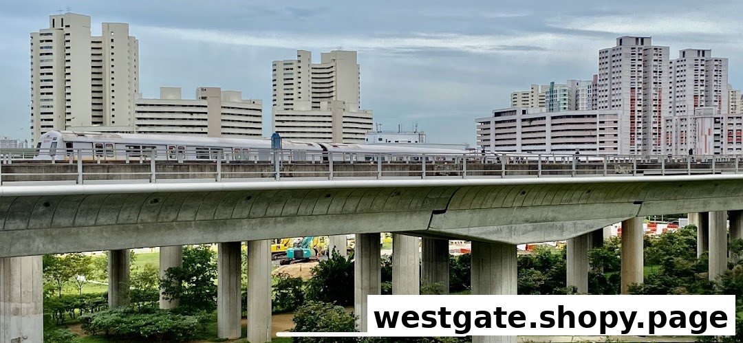 An elevated train track with a train passing, surrounded by residential buildings and lush greenery.