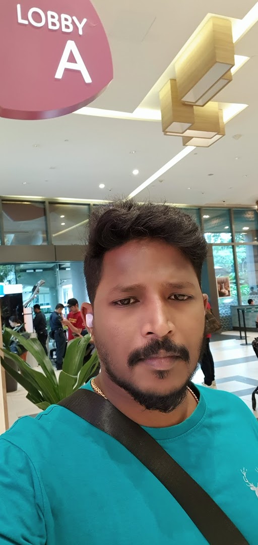 A person takes a selfie in a bright, modern shopping mall lobby with a 'LOBBY A' sign.