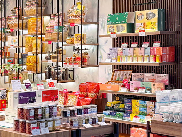 Shelves filled with a variety of packaged food, health products, and gift sets in a retail store.