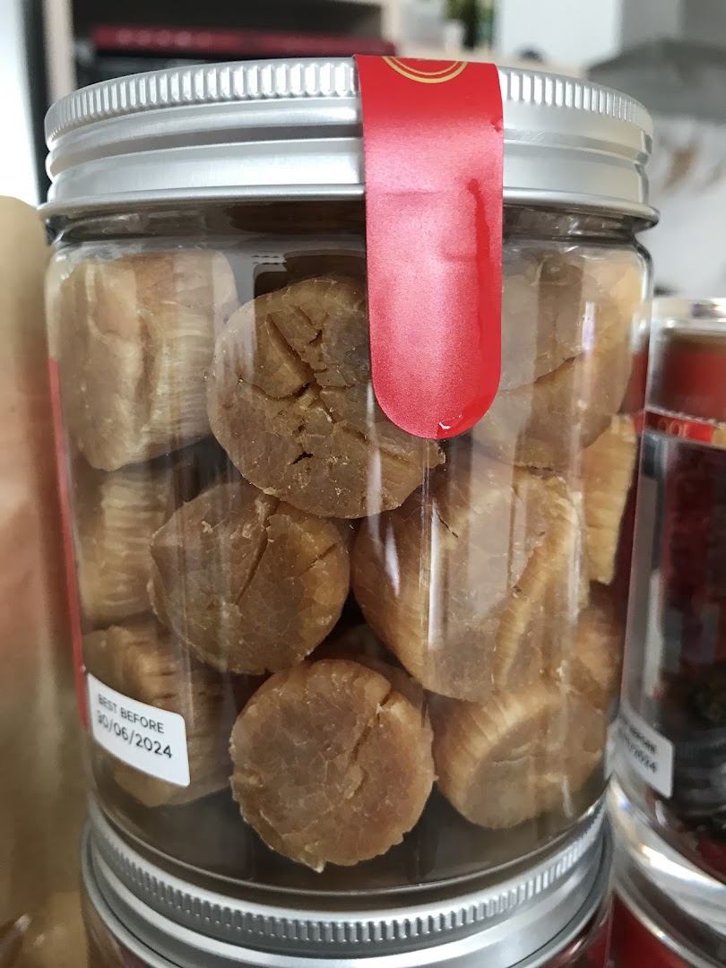 A clear glass jar filled with premium dried scallops, featuring a red label and a 'best before' date.