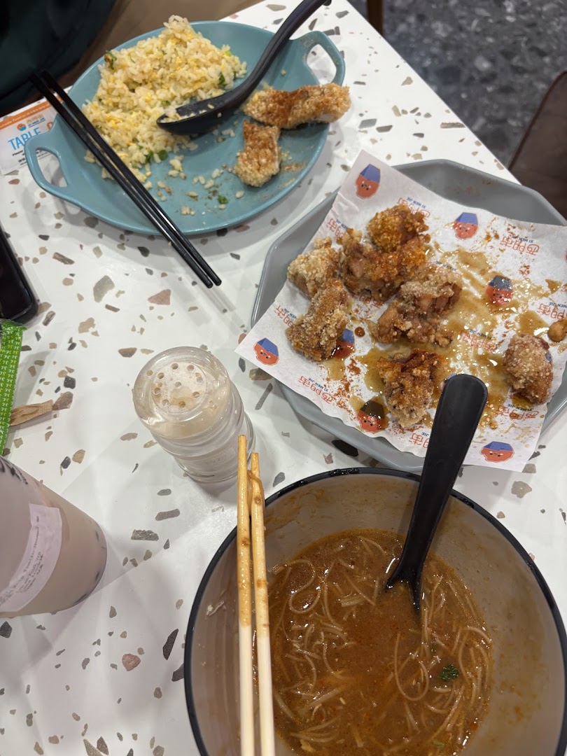 A table laden with delicious Taiwanese dishes, including fried chicken, fried rice, and noodles.