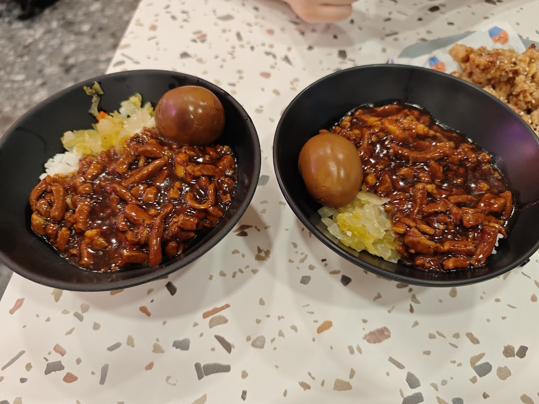 Two bowls of delicious Taiwanese braised pork rice (Lu Rou Fan) with a braised egg and pickled vegetables.
